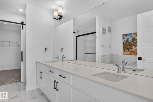 Dual vanity with light-toned countertop and undermount sinks - 23027 96 Avenue Nw, Edmonton, AB - Indoor Photo Showing Other Room