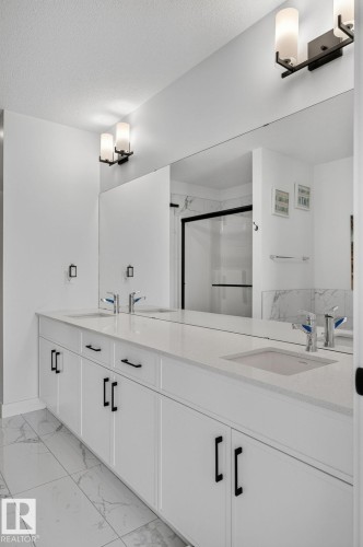 White dual vanity featuring integrated sinks and quartz countertops - 23027 96 Avenue Nw, Edmonton, AB - Indoor Photo Showing Bathroom