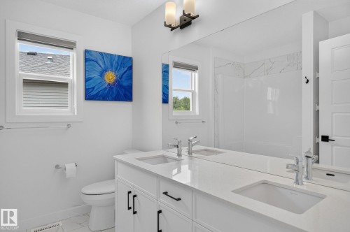 Double vanity with undermount sinks and chrome faucets, featuring a spacious quartz countertop - 23027 96 Avenue Nw, Edmonton, AB - Indoor Photo Showing Bathroom