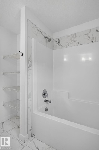 White tub and shower combination with chrome fixtures - 23027 96 Avenue Nw, Edmonton, AB - Indoor Photo Showing Bathroom