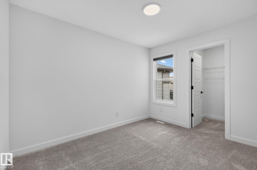 Carpeted room featuring a single window, a flush mount ceiling light, and a closet with a paneled door - 23027 96 Avenue Nw, Edmonton, AB - Indoor Photo Showing Other Room