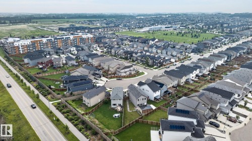 Expansive aerial showcasing a contemporary residential development with single-family homes and multi-story apartment buildings - 23027 96 Avenue Nw, Edmonton, AB - Outdoor With View