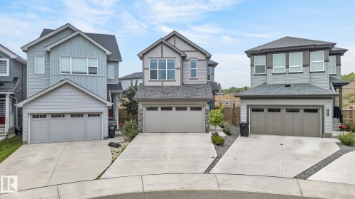Contemporary two-story residence with a gray siding exterior, dark trim accents, a prominent front entry, attached two-car garage, and a concrete driveway - 23027 96 Avenue Nw, Edmonton, AB - Outdoor With Facade