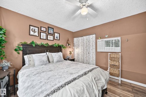 Wood-finish flooring with a ceiling fan light fixture - 64 Habitat Crescent Nw, Edmonton, AB - Indoor Photo Showing Bedroom