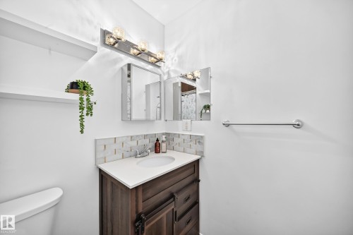 Dark wood-finish vanity with a white countertop and undermount sink - 64 Habitat Crescent Nw, Edmonton, AB - Indoor Photo Showing Bathroom