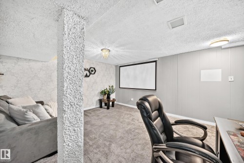 Textured ceiling, wall paneling, projector screen, recessed lighting, and a decorative ceiling fixture - 64 Habitat Crescent Nw, Edmonton, AB - Indoor