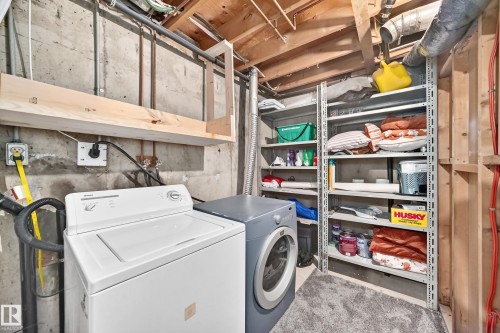 Laundry area featuring a top-load washing machine, front-load drying machine, and built-in shelving - 64 Habitat Crescent Nw, Edmonton, AB - Indoor Photo Showing Laundry Room