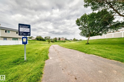 Paved pathway bordered by manicured green spaces and mature trees - 64 Habitat Crescent Nw, Edmonton, AB - Outdoor