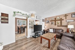 Wood-finish flooring throughout, with a dining area featuring a window, and a living area with warm-toned walls - 