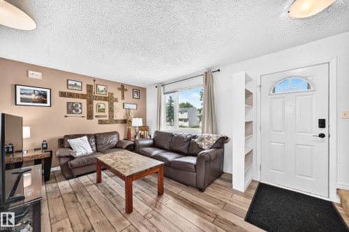 Entry door with decorative arch window and built-in shelving - 64 Habitat Crescent Nw, Edmonton, AB - Indoor Photo Showing Living Room