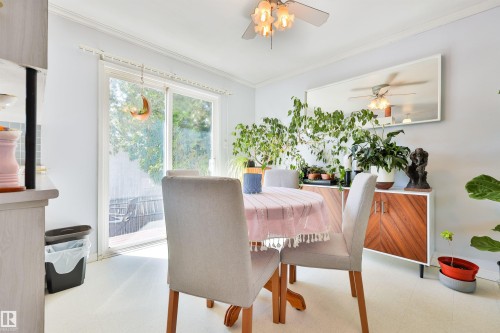 Sliding glass door opening to the deck outdoor space, crown molding, and ceiling fan with integrated lighting - 3824 111B Street Nw, Edmonton, AB - Indoor Photo Showing Other Room