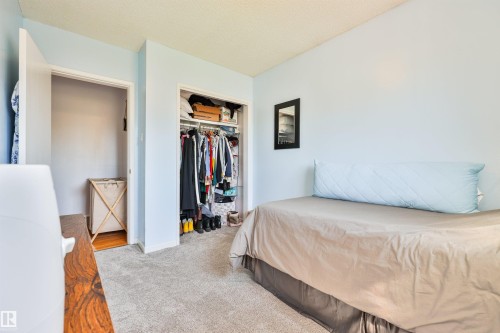 Second bedroom on main level. Light blue wall finish with textured ceiling, two open doorways, and gray carpet flooring - 3824 111B Street Nw, Edmonton, AB - Indoor Photo Showing Bedroom