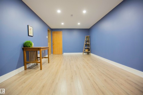 Spacious room with vibrant periwinkle walls and crisp white ceiling - 9107 58 Street Nw, Edmonton, AB - Indoor Photo Showing Other Room