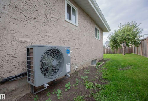Modern heat pump system installed on the exterior, complementing the textured stucco facade - 9107 58 Street Nw, Edmonton, AB - Outdoor With Exterior