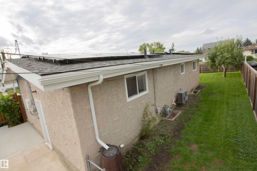 Modern residential addition featuring a flat roof with integrated guttering, stucco exterior walls, and large fixed windows - 9107 58 Street Nw, Edmonton, AB - Outdoor