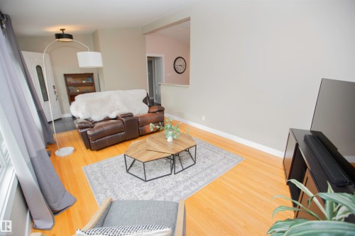 Hardwood flooring throughout, neutral wall tones, and an open entryway - 9107 58 Street Nw, Edmonton, AB - Indoor Photo Showing Living Room