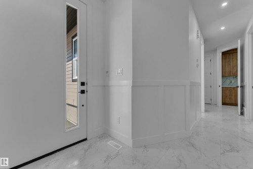 White paneled wainscoting, recessed lighting, and a partial light wood-finish built-in cabinet - 2039 156 Avenue Nw, Edmonton, AB - Indoor Photo Showing Other Room