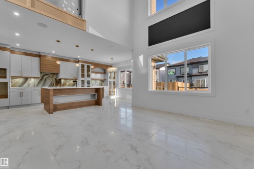 Spacious open-concept interior featuring high ceilings, large windows, and white marble-look flooring - 2039 156 Avenue Nw, Edmonton, AB - Indoor
