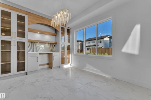 Built-in custom cabinetry with glass-front uppers, integrated desk, and wood-finish accents - 2039 156 Avenue Nw, Edmonton, AB - Indoor Photo Showing Other Room