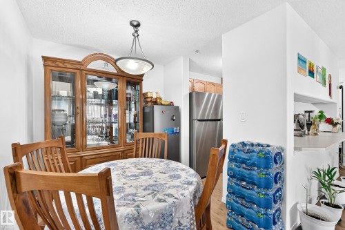 Recessed lighting, wood-finish flooring, and a stainless steel refrigerator - #324 279 Suder Greens Dr Nw, Edmonton, AB - Indoor Photo Showing Dining Room