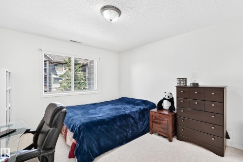 Carpeted room featuring a double window with blinds, white walls, and a semi-flush mount ceiling light - #324 279 Suder Greens Dr Nw, Edmonton, AB - Indoor Photo Showing Bedroom