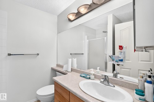Vanity with integrated sink, chrome faucet, and expansive mirror - #324 279 Suder Greens Dr Nw, Edmonton, AB - Indoor Photo Showing Bathroom