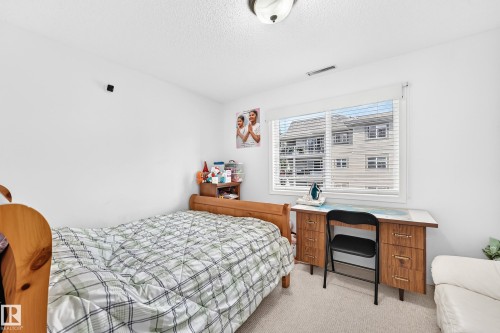 Textured ceiling with a flush-mount light fixture - #324 279 Suder Greens Dr Nw, Edmonton, AB - Indoor Photo Showing Bedroom
