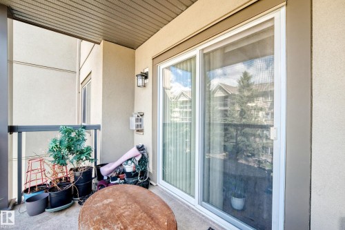 Balcony featuring a clear panel railing, exterior wall sconce, and sliding glass door - #324 279 Suder Greens Dr Nw, Edmonton, AB - Outdoor With Exterior