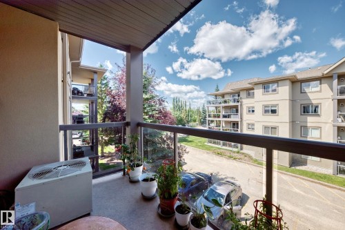 Balcony featuring a glass railing and a concrete floor - #324 279 Suder Greens Dr Nw, Edmonton, AB - Outdoor With Balcony With Exterior