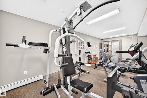 Dedicated fitness area featuring neutral wall tones, recessed lighting, and a textured carpeted floor - #324 279 Suder Greens Dr Nw, Edmonton, AB - Indoor Photo Showing Gym Room