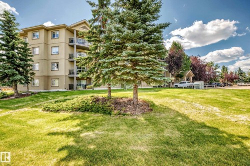 Multi-story building with a light-colored stucco exterior, featuring multiple balconies with metal railings - #324 279 Suder Greens Dr Nw, Edmonton, AB - Outdoor With Balcony