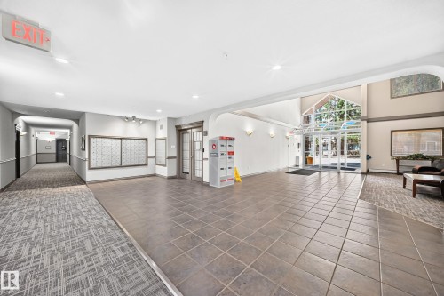Spacious lobby with tile flooring, a large glass-paneled entrance, and a mail area - #324 279 Suder Greens Dr Nw, Edmonton, AB - Indoor Photo Showing Other Room