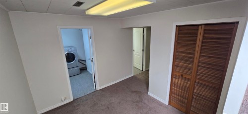 Neutral wall finishes, recessed lighting, brown carpeting, and a louvered bi-fold closet - 4317 50 Street, Vegreville, AB - Indoor Photo Showing Other Room