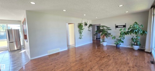 Hardwood-style flooring throughout, recessed ceiling lighting, and expansive windows - 4317 50 Street, Vegreville, AB - Indoor Photo Showing Other Room