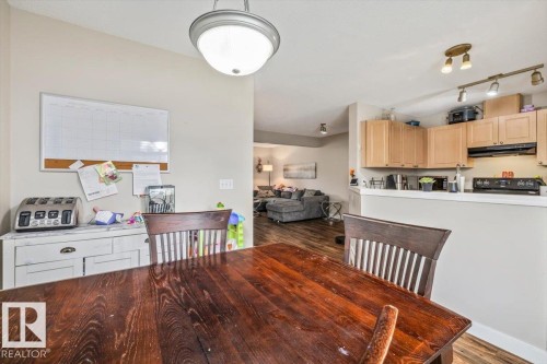Recessed lighting, wood-finish flooring, light wood cabinetry, and a black range - 4744 Terwillegar Common Nw, Edmonton, AB - Indoor Photo Showing Kitchen