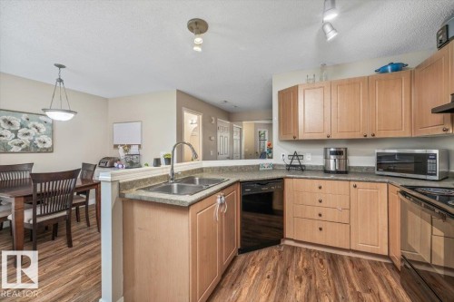 Kitchen with wood-finish flooring, light wood cabinetry, and a double basin sink - 4744 Terwillegar Common Nw, Edmonton, AB - Indoor Photo Showing Kitchen With Double Sink