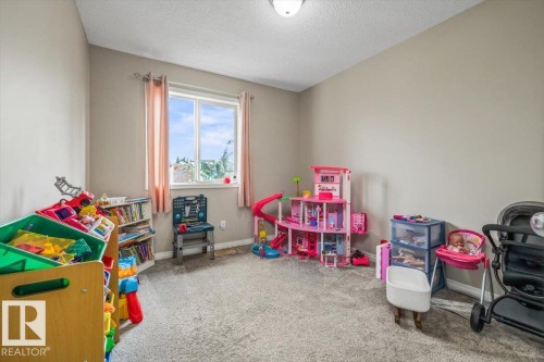 Carpeted room featuring neutral-toned walls, a single window, and a flush-mount ceiling light fixture - 4744 Terwillegar Common Nw, Edmonton, AB - Indoor