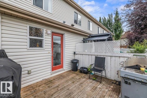 Wood deck with a red exterior door, white siding, and a privacy fence with lattice detail - 4744 Terwillegar Common Nw, Edmonton, AB - Outdoor With Deck Patio Veranda With Exterior