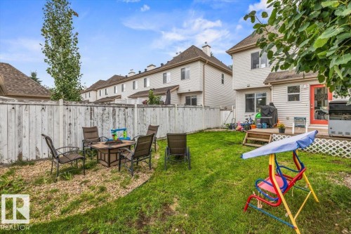 Expansive backyard with a wooden fence, green lawn, and gravel patio area - 4744 Terwillegar Common Nw, Edmonton, AB - Outdoor With Deck Patio Veranda