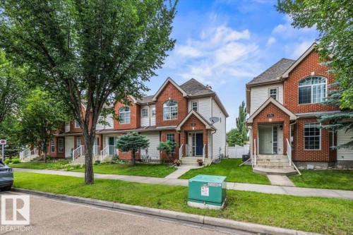 Brick and siding exterior, arched windows, gabled roofline, concrete walkways, and mature landscaping - 4744 Terwillegar Common Nw, Edmonton, AB - Outdoor With Facade