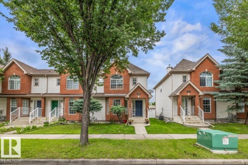Brick and siding exterior with arched windows, gabled rooflines, and covered front entrances - 4744 Terwillegar Common Nw, Edmonton, AB - Outdoor With Facade
