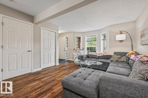 Wood-finish flooring throughout, light neutral paint, and bay windows - 4744 Terwillegar Common Nw, Edmonton, AB - Indoor Photo Showing Living Room