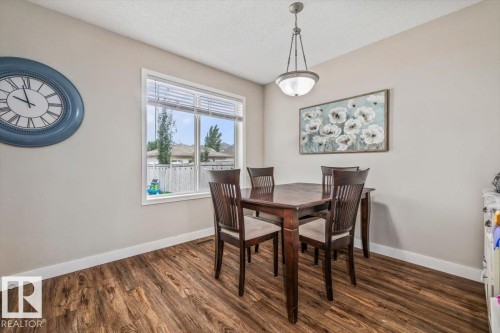 Wood-finish flooring, neutral wall tones, and an overhead pendant light fixture - 4744 Terwillegar Common Nw, Edmonton, AB - Indoor Photo Showing Dining Room