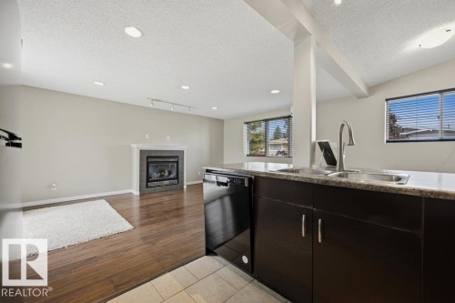 7119 136 Avenue Nw, Edmonton, AB - Indoor Photo Showing Kitchen With Fireplace With Double Sink