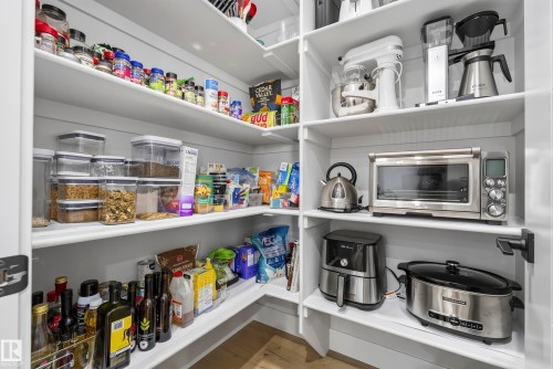 Built-in pantry shelving with white finishes and wood-finish flooring - 7314 Morgan Road Nw, Edmonton, AB - Indoor With Storage