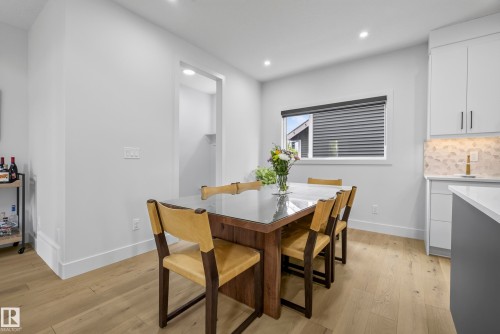 Recessed lighting, light wood-finish flooring, built-in shelving, white cabinetry, and a textured backsplash - 7314 Morgan Road Nw, Edmonton, AB - Indoor Photo Showing Dining Room