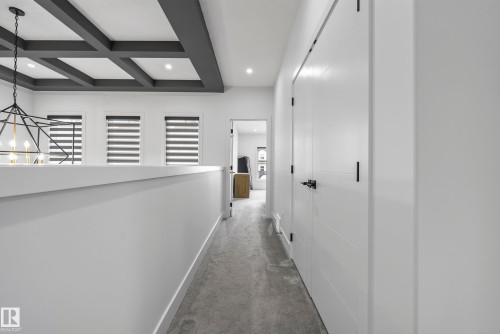 Coffered ceiling with recessed lighting, three windows with blinds, geometric chandelier, white panel doors, and wall-to-wall carpeting - 7314 Morgan Road Nw, Edmonton, AB - Indoor Photo Showing Other Room