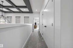 Coffered ceiling with recessed lighting, three windows with blinds, geometric chandelier, white panel doors, and wall-to-wall carpeting - 
