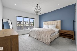 Recessed lighting, geometric chandelier, large window, accent wall, and light-colored carpeting - 