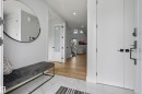 Entryway featuring white marble-look tile flooring and a round wall-mounted mirror - 7314 Morgan Road Nw, Edmonton, AB  - Indoor Photo Showing Other Room 